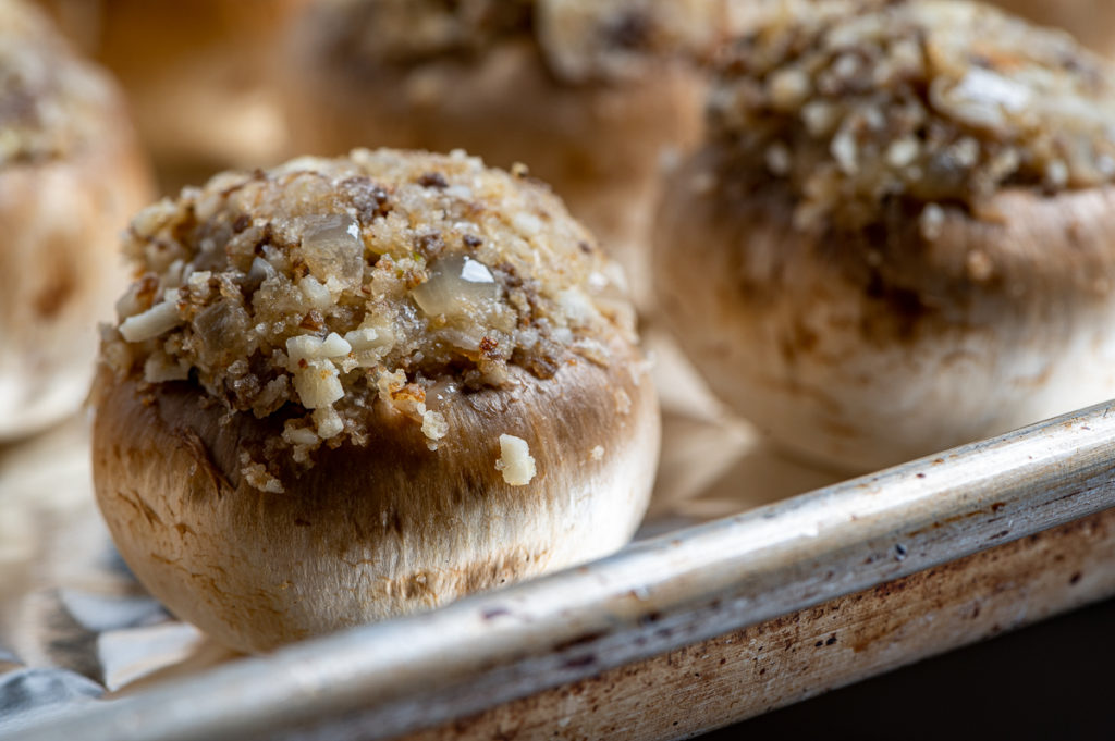 A mushroom stuffed with breadcrumbs and cheese ready to be baked.