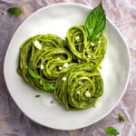 Three rounds of pasta covered in Peruvian pesto on a white plate.