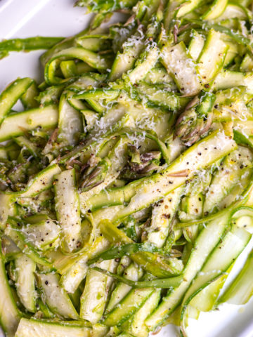 Shaved asparagus salad on a white platter.