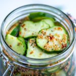 Kirby cucumbers sliced in a jar covered in pickling brine.