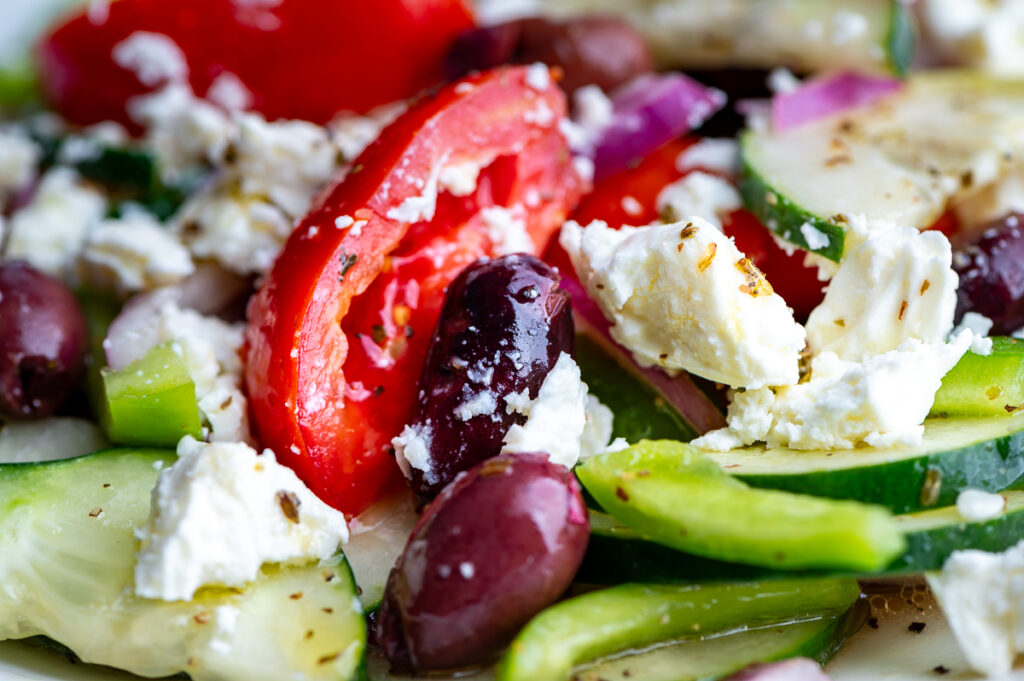 Closeup of tomatoes, olives, peppers and feta.