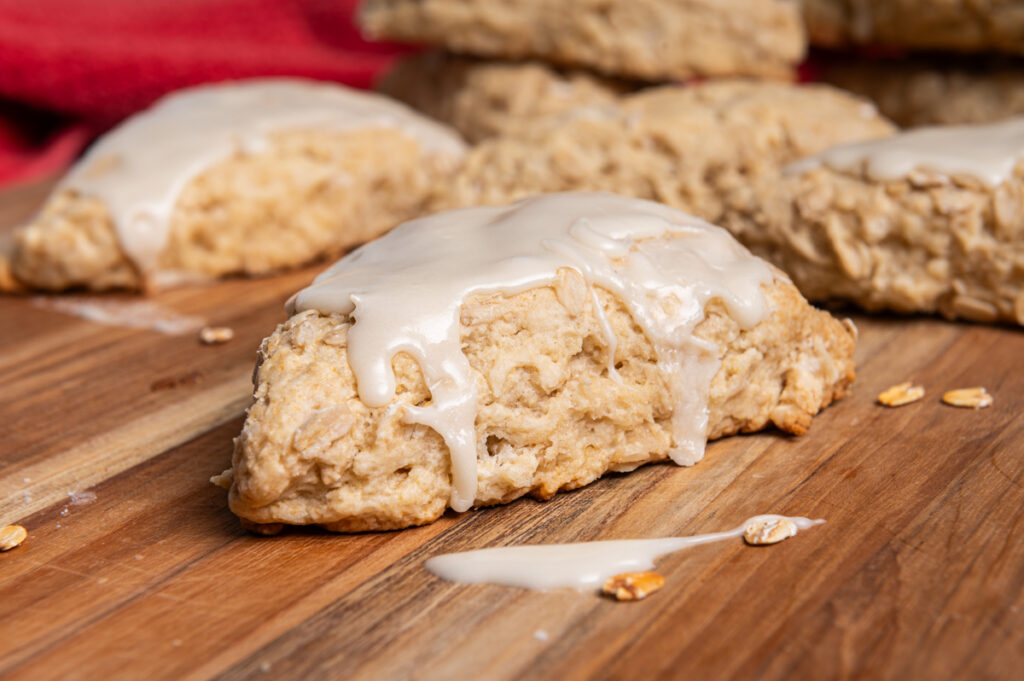 A side view of an iced scone on a board.