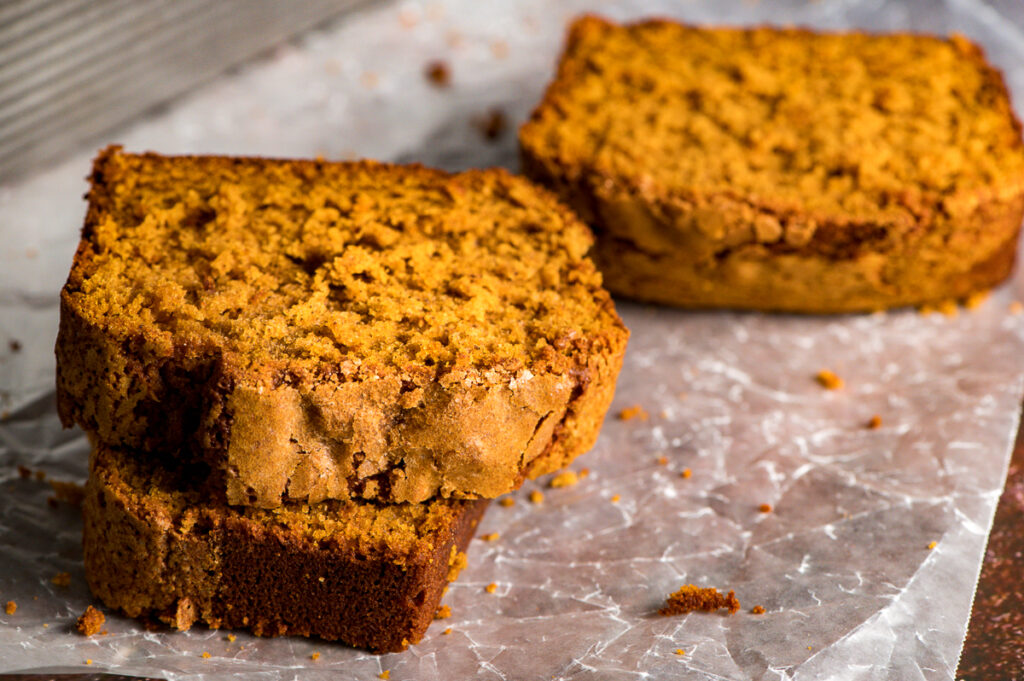 Slices of pumpkin bread on parchment paper.