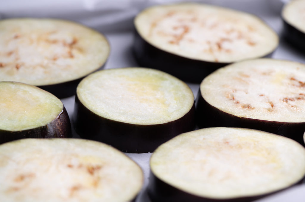 Slices of eggplant on a baking sheet.