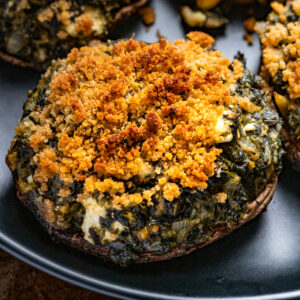 Spinach and Feta Stuffed Portabello Mushroom on a black plate.
