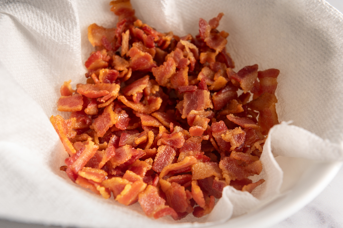 Diced cooked bacon on a paper towel.