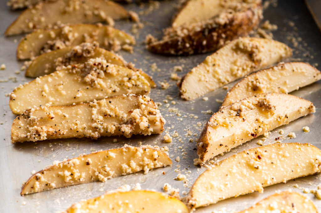 Potato wedges covered in parmesan dressing.
