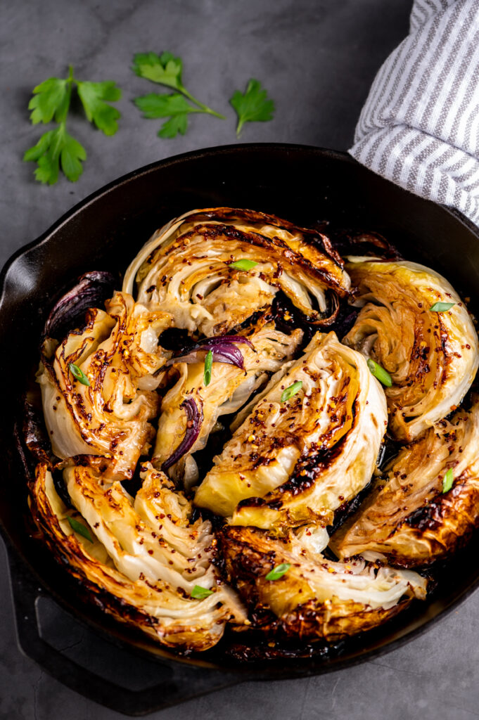 A skillet of roasted cabbage with hot honey.
