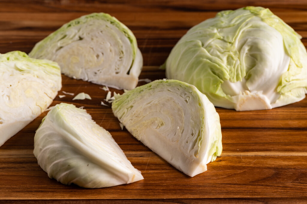 Sliced cabbage wedges on a board.