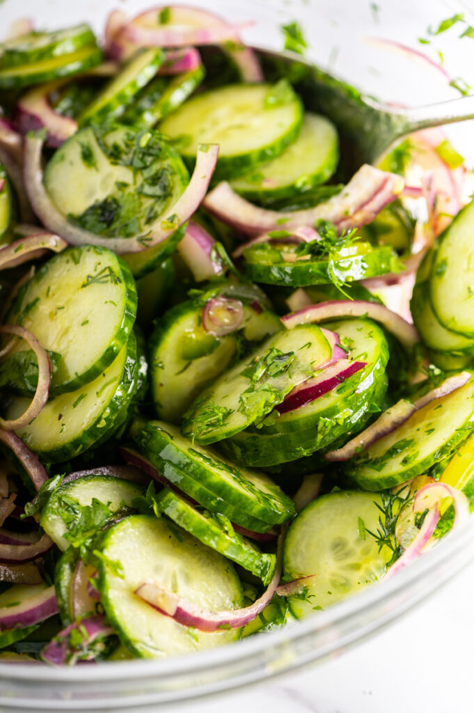 Sliced cucumbers with sliced red onions.