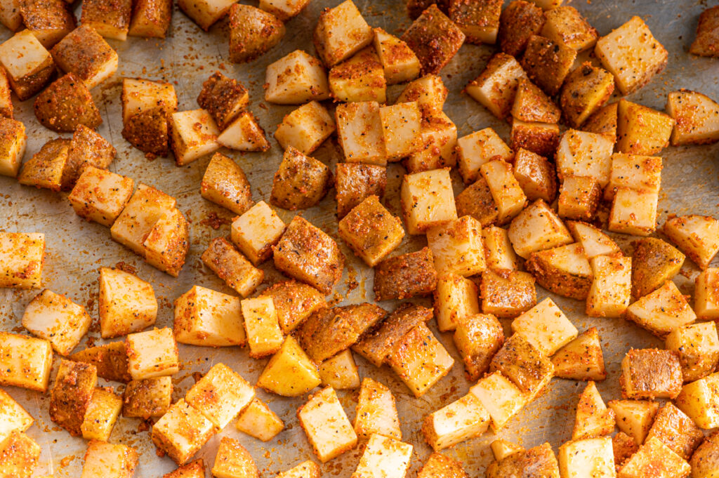 Cubed spiced potatoes ready for roasting.