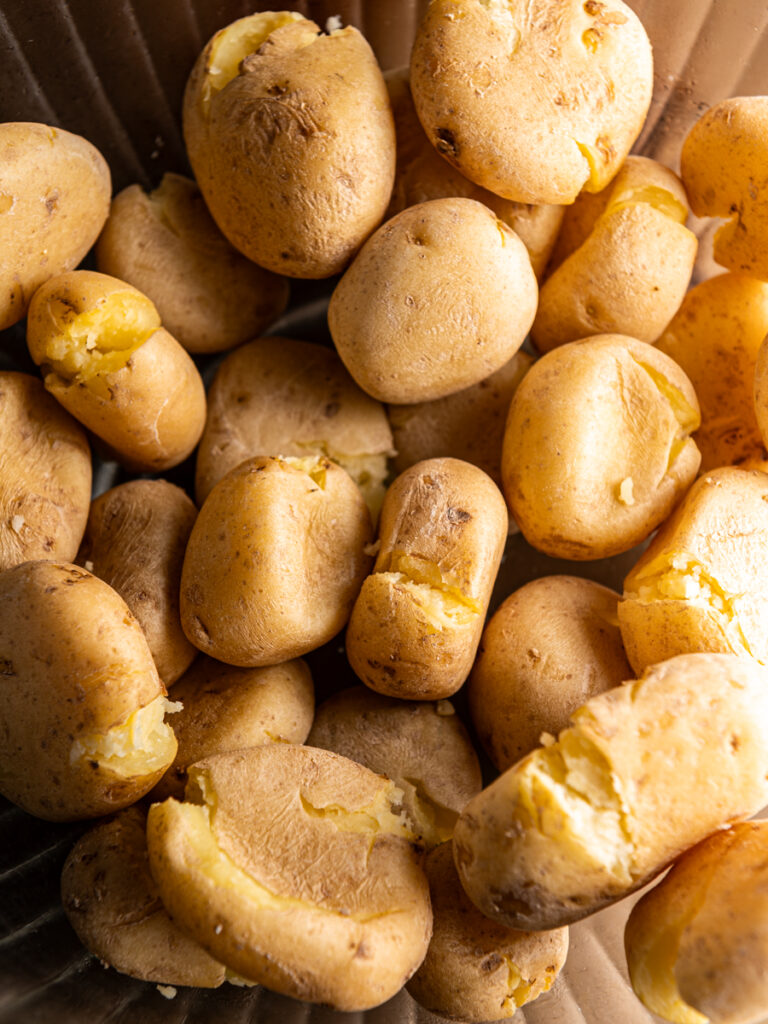 Baby yellow potatoes slightly smashed in a bowl.