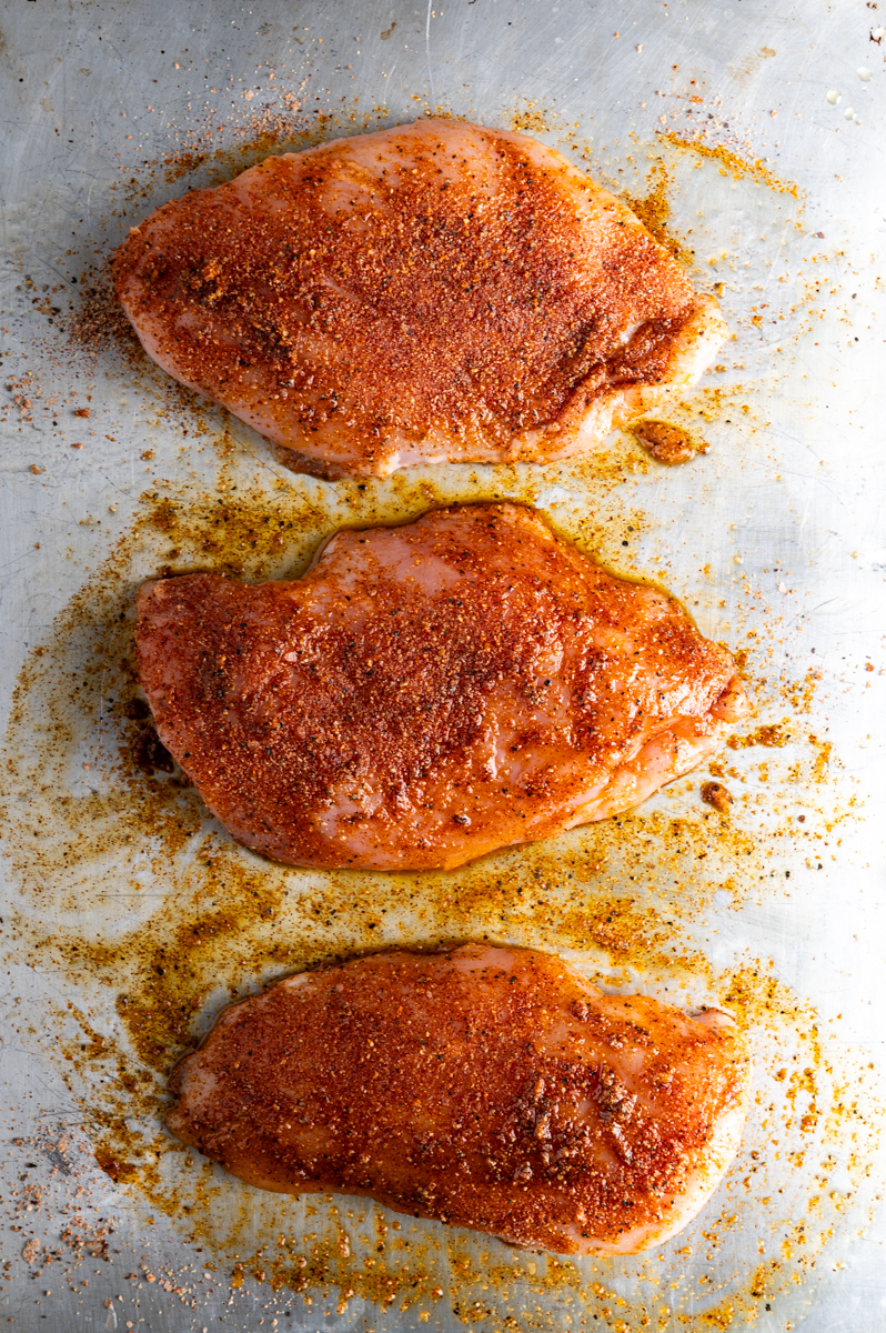 Seasoned chicken breasts ready to bake.