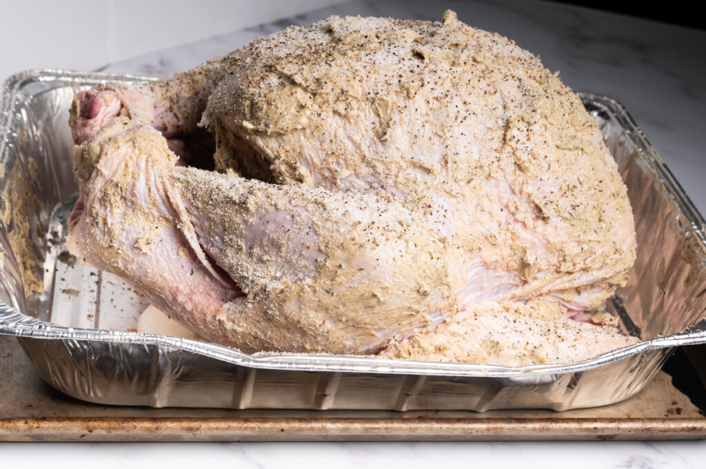 Side view of a seasoned buttered turkey.