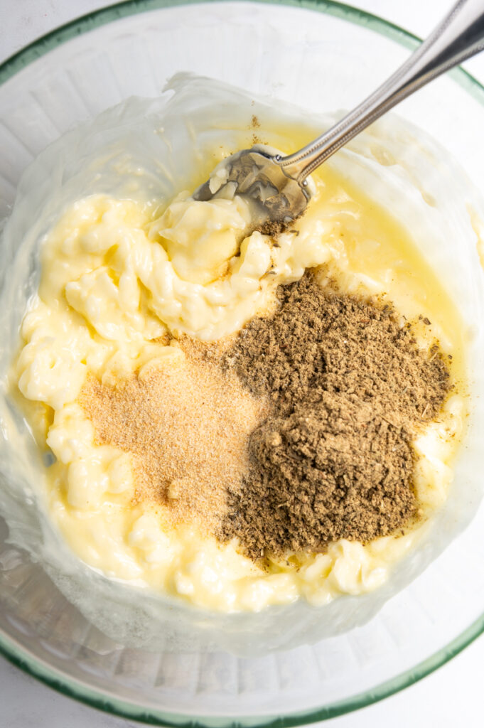Butter in a bowl topped with dried seasonings.