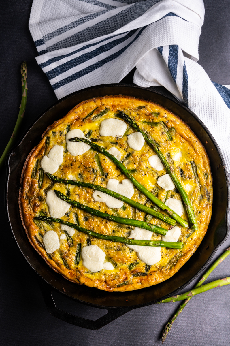 A baked asparagus frittata in a cast iron skillet.